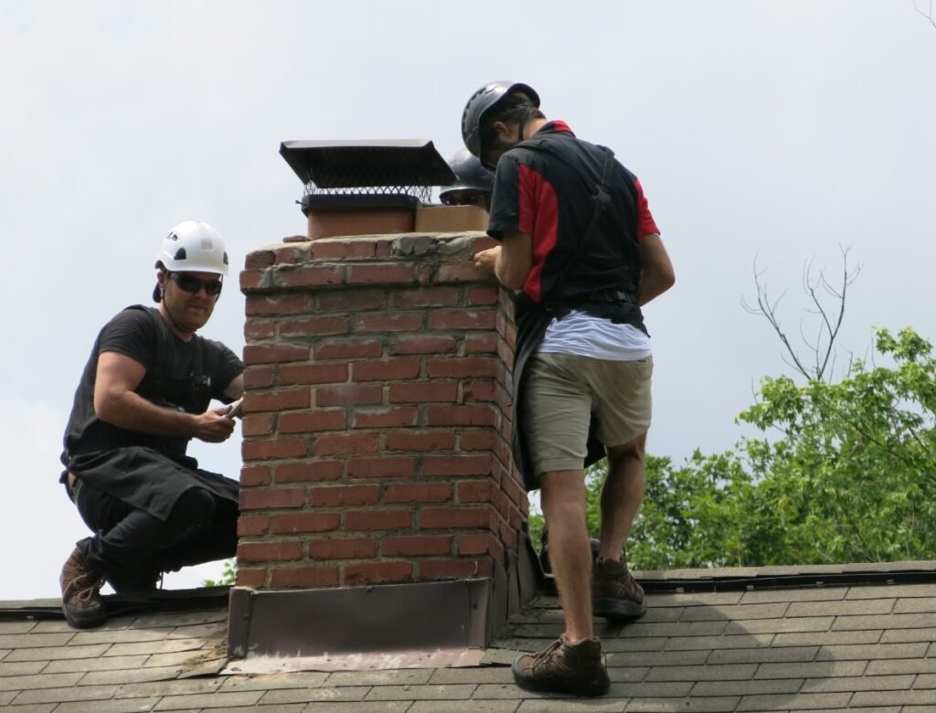Professional chimney sweep removing creosote and soot buildup during chimney cleaning in North Carolina.