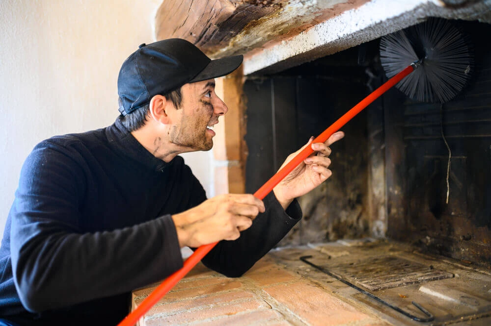technician performing a chimney sweep